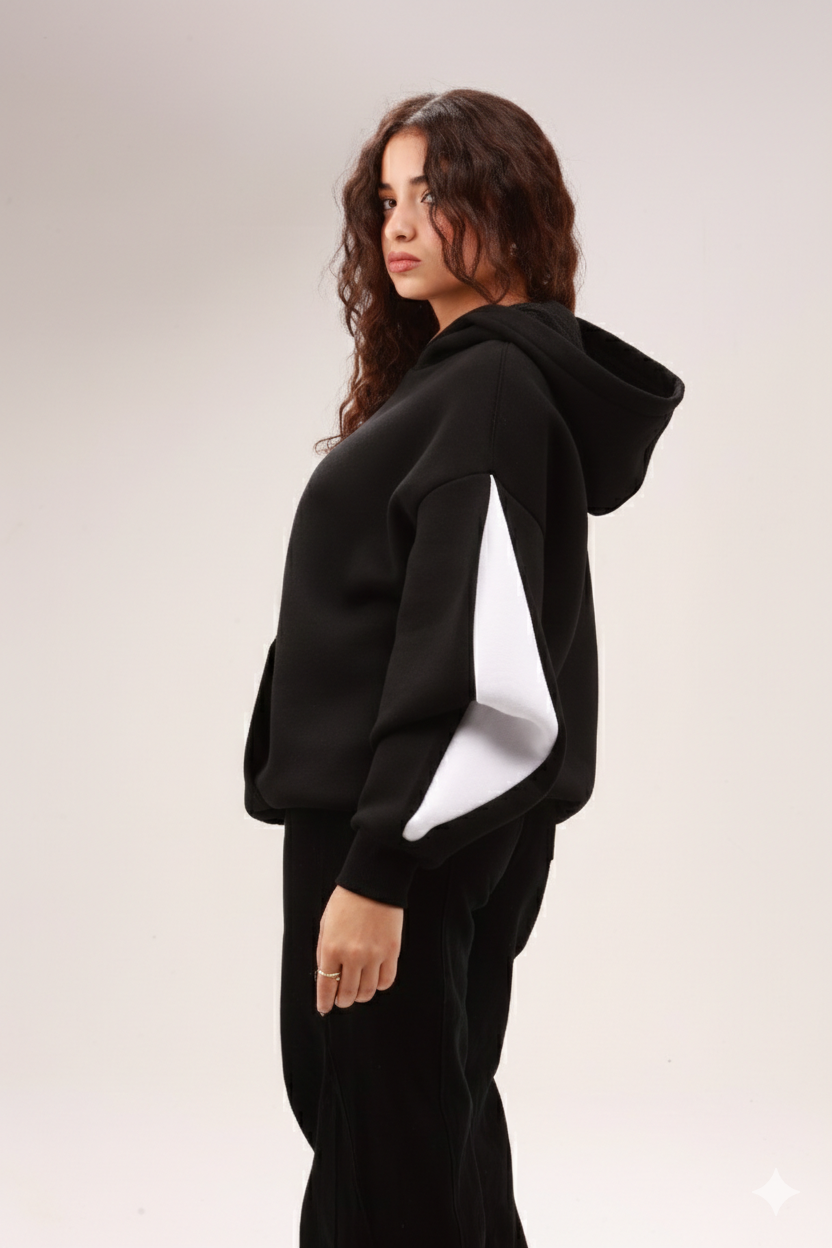 Woman in black hoodie with white sleeve detail, casual basic fashion, neutral background